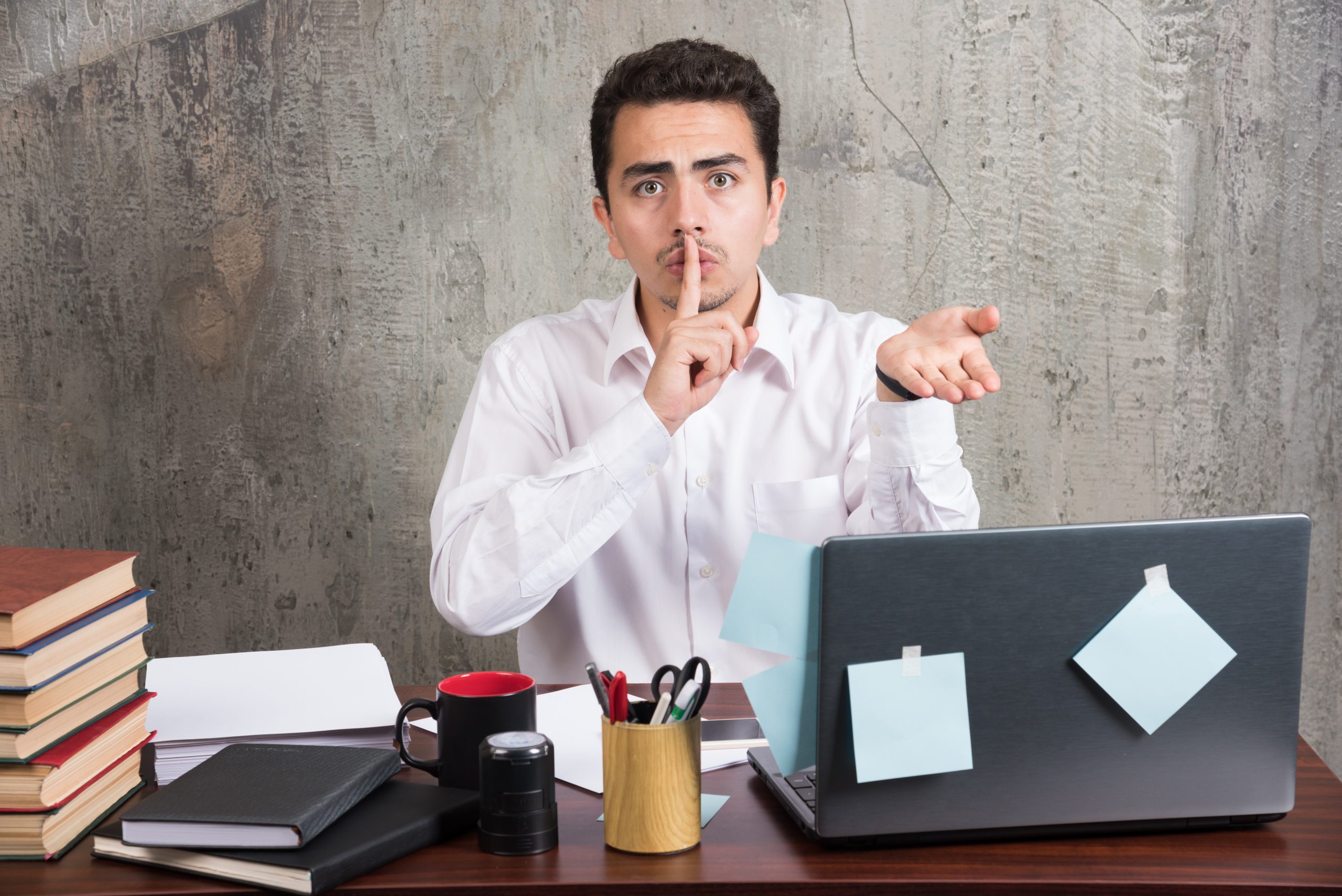 A PhD student looking stressed at their desk, with a thought bubble showing a question mark.