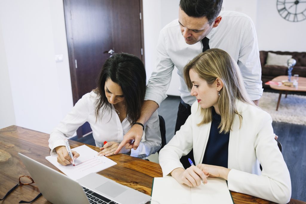 A focused student working on GRE quantitative reasoning problems with a notepad and calculator, practicing for the exam.