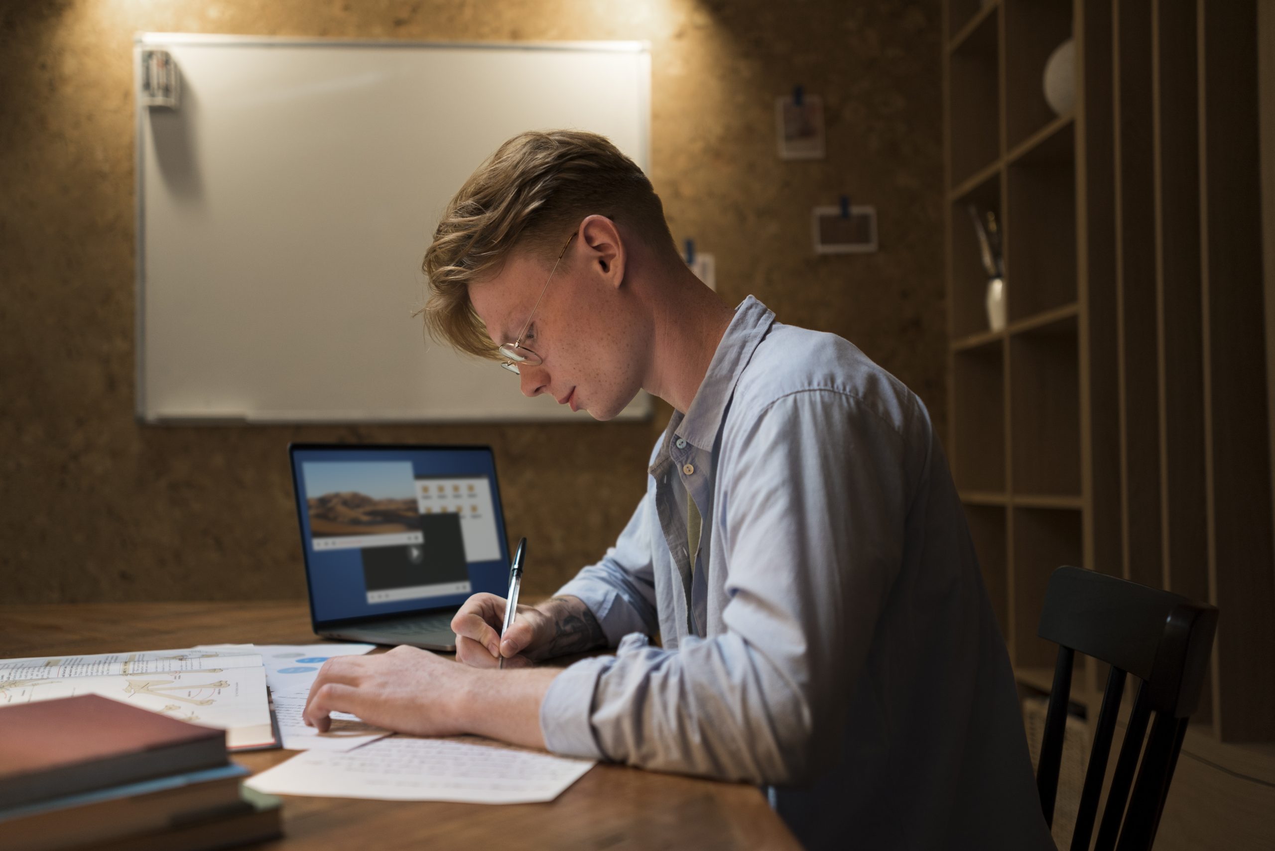 A graduate student focused on writing their Statement of Purpose on a laptop in a quiet library setting.